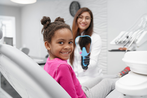  child sitting in dental chair with sealants